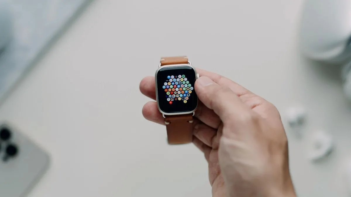 Một chiếc Apple Watch Series 7 với dây da được cầm trên tay, minh họa thiết kế truyền thống của đồng hồ thông minh.