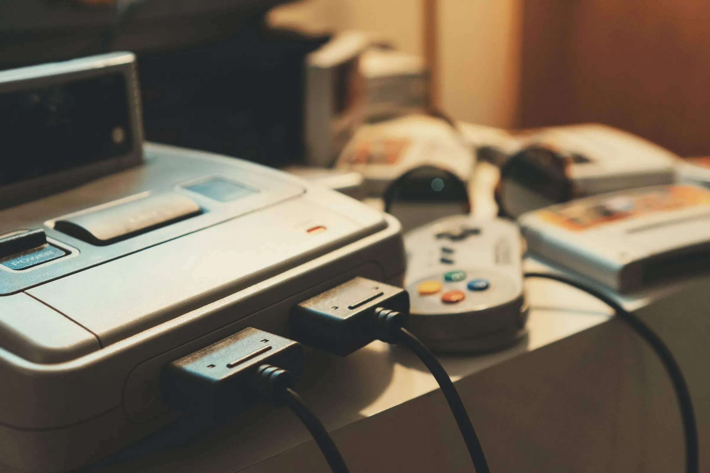 Một chiếc console chơi game retro với tay cầm được đặt trên nền tối, tạo cảm giác hoài cổ và bí ẩn.