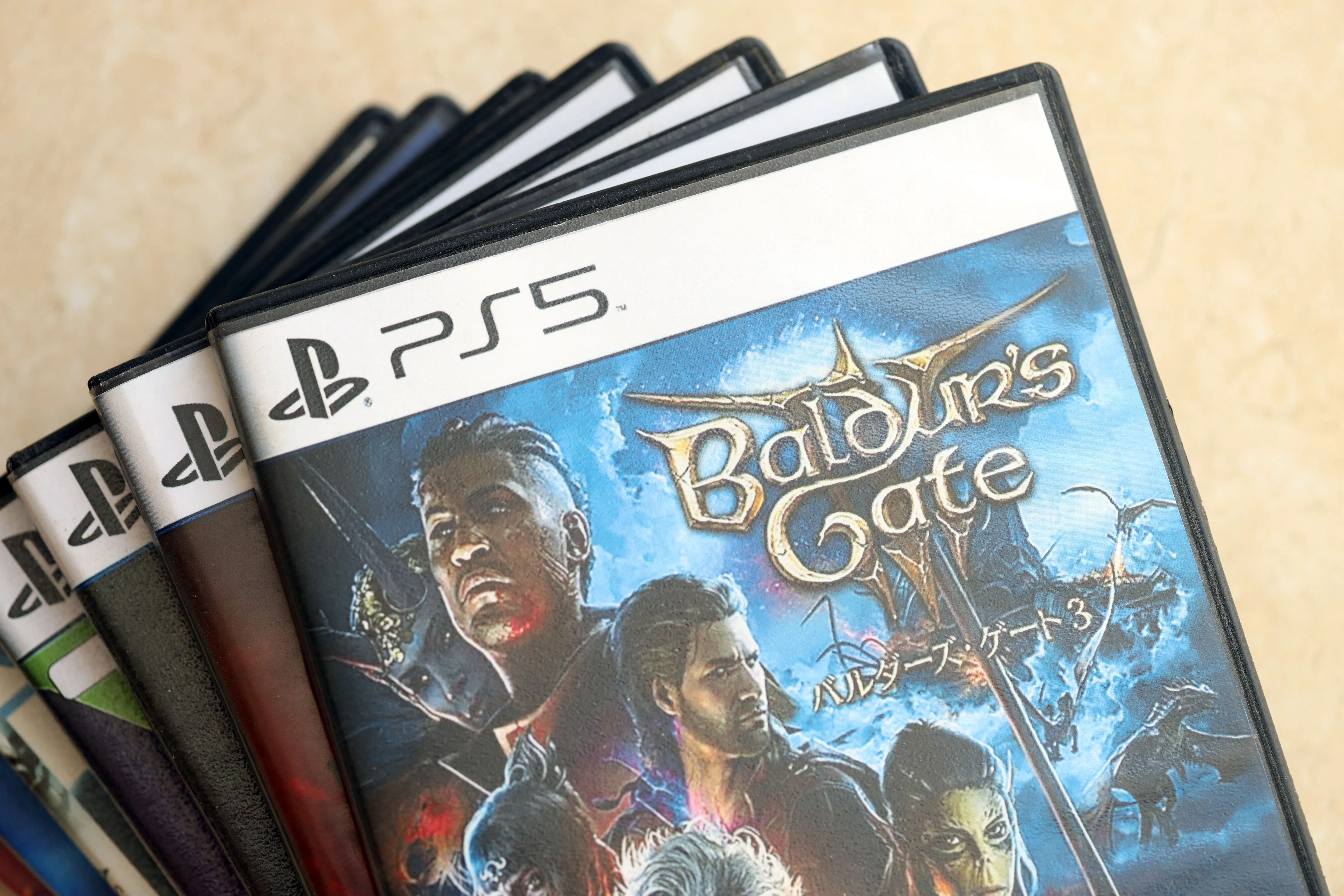 Một chồng đĩa game PS5 với tựa game Baldur's Gate 3 đặt trên cùng, minh họa cho bộ sưu tập game vật lý và quyền sở hữu.