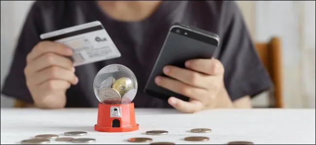 Một người đàn ông đang chăm chú chơi gacha game trên điện thoại thông minh, thể hiện sự cuốn hút của trò chơi di động