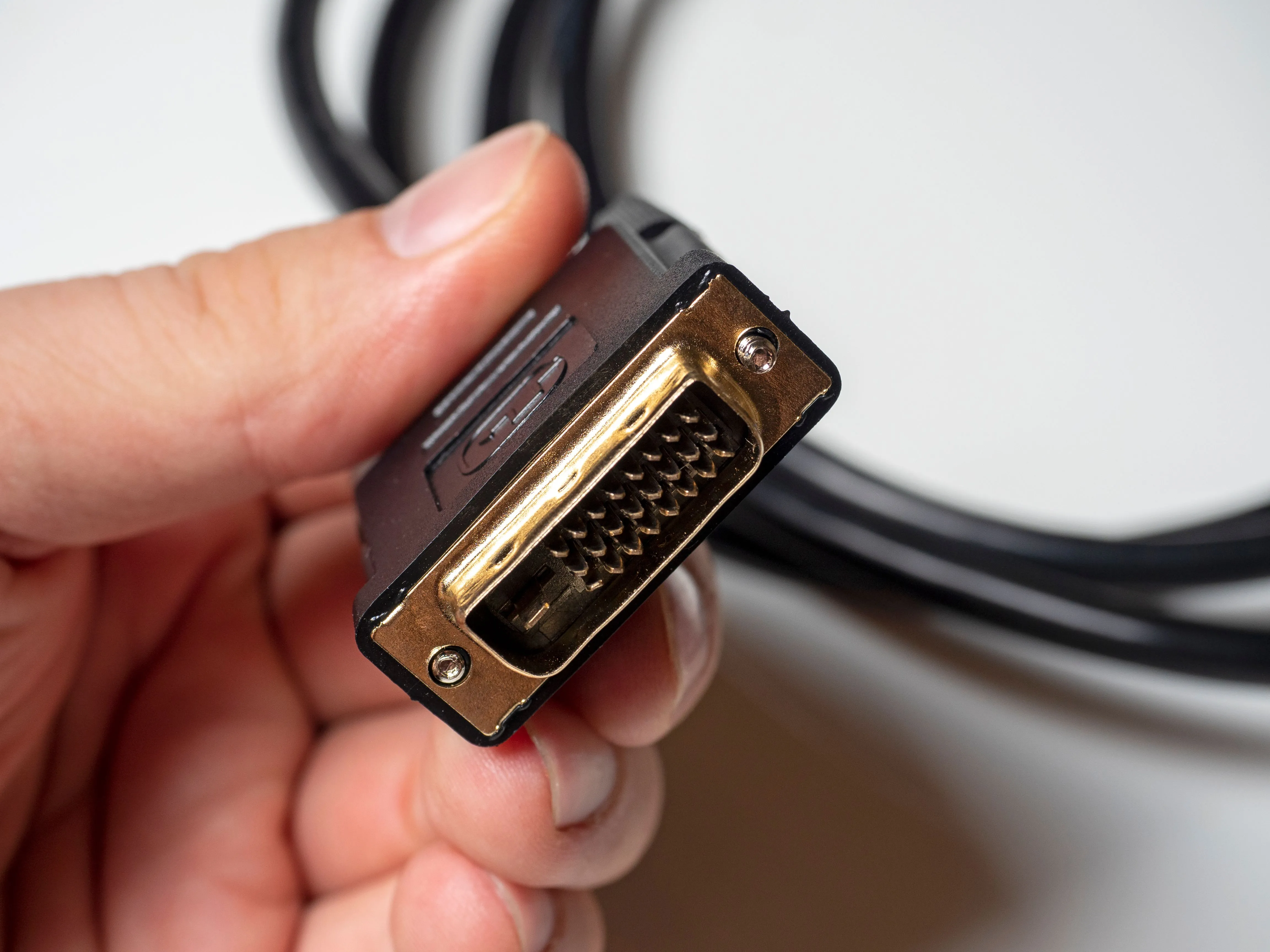 Một người đang cầm cáp kết nối DVI, chuẩn video kỹ thuật số cũ.