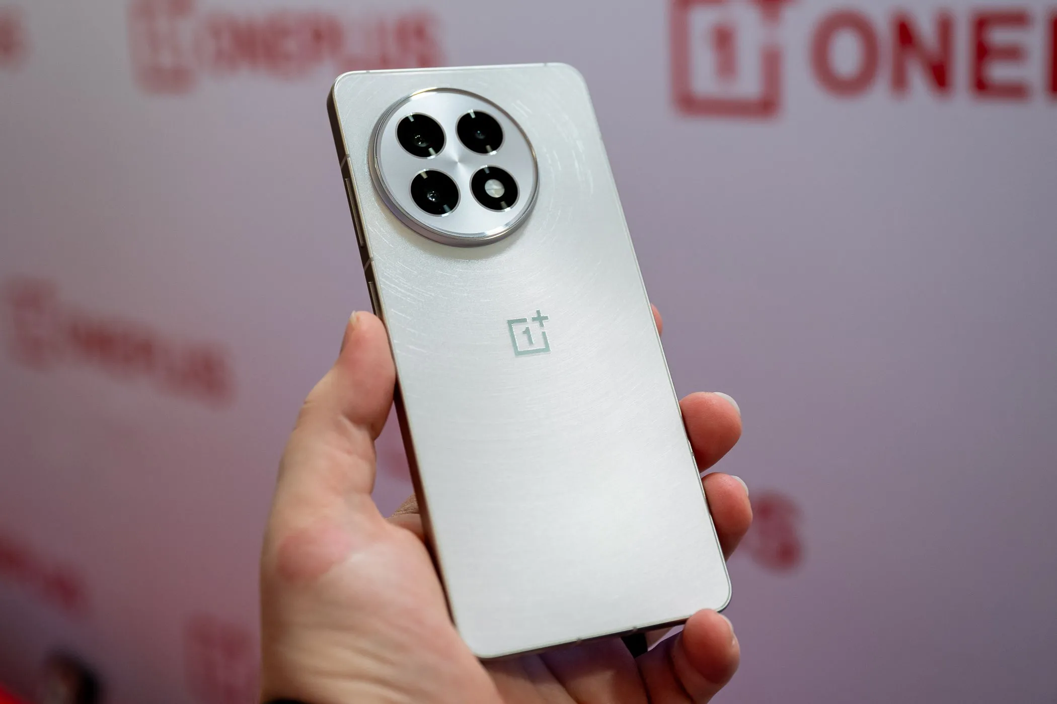 Một người đang cầm điện thoại OnePlus 13R màu trắng, thể hiện thiết kế tinh tế và hiện đại của thiết bị