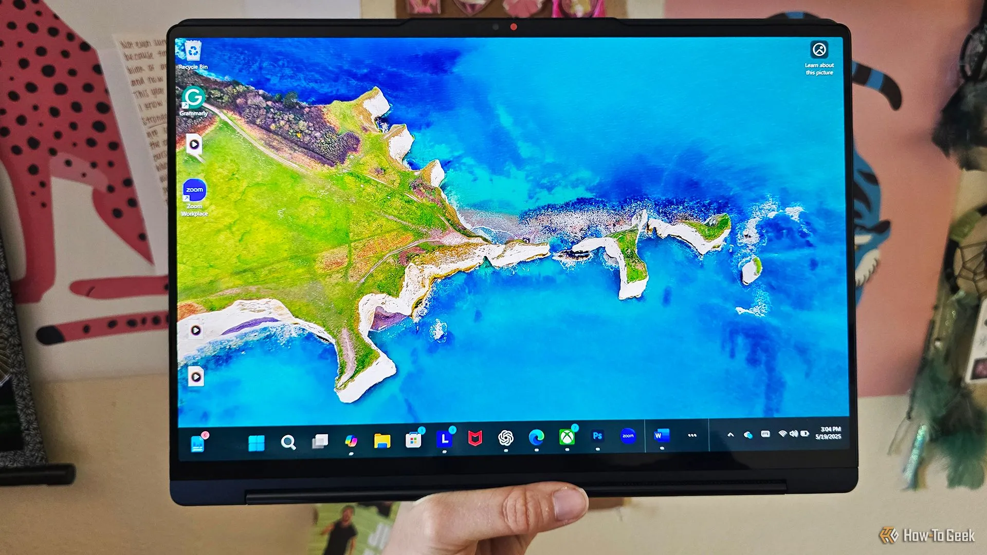 Một người đang cầm laptop Lenovo Yoga 9i 2-in-1 Gen 10 ở chế độ máy tính bảng, thể hiện tính linh hoạt của thiết bị.