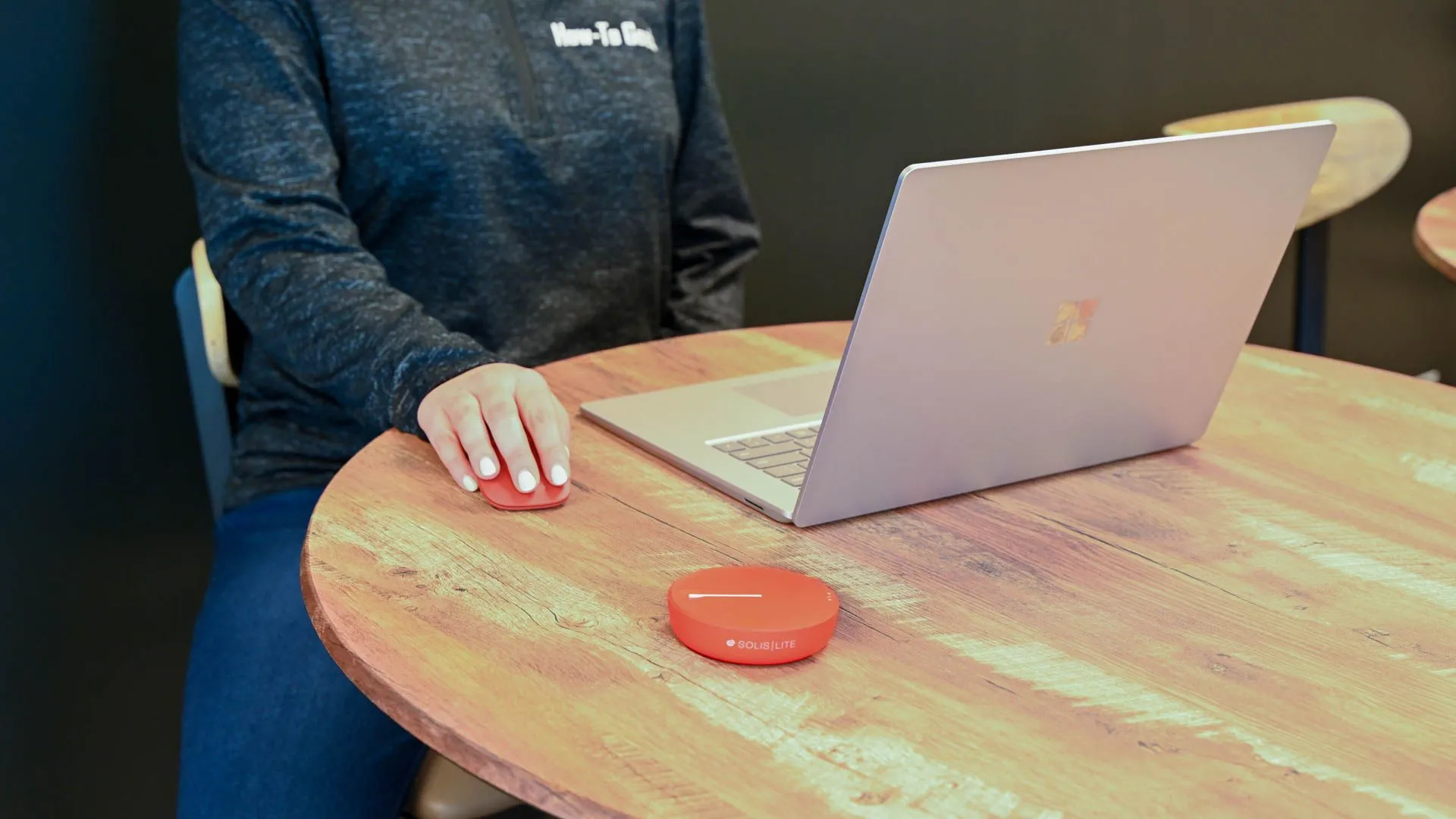 Một người đang cầm thiết bị phát Wi-Fi di động Solis Lite nhỏ gọn, màu cam, sử dụng trong môi trường ngoài trời, tượng trưng cho kết nối internet linh hoạt khi du lịch quốc tế, hỗ trợ 4G.