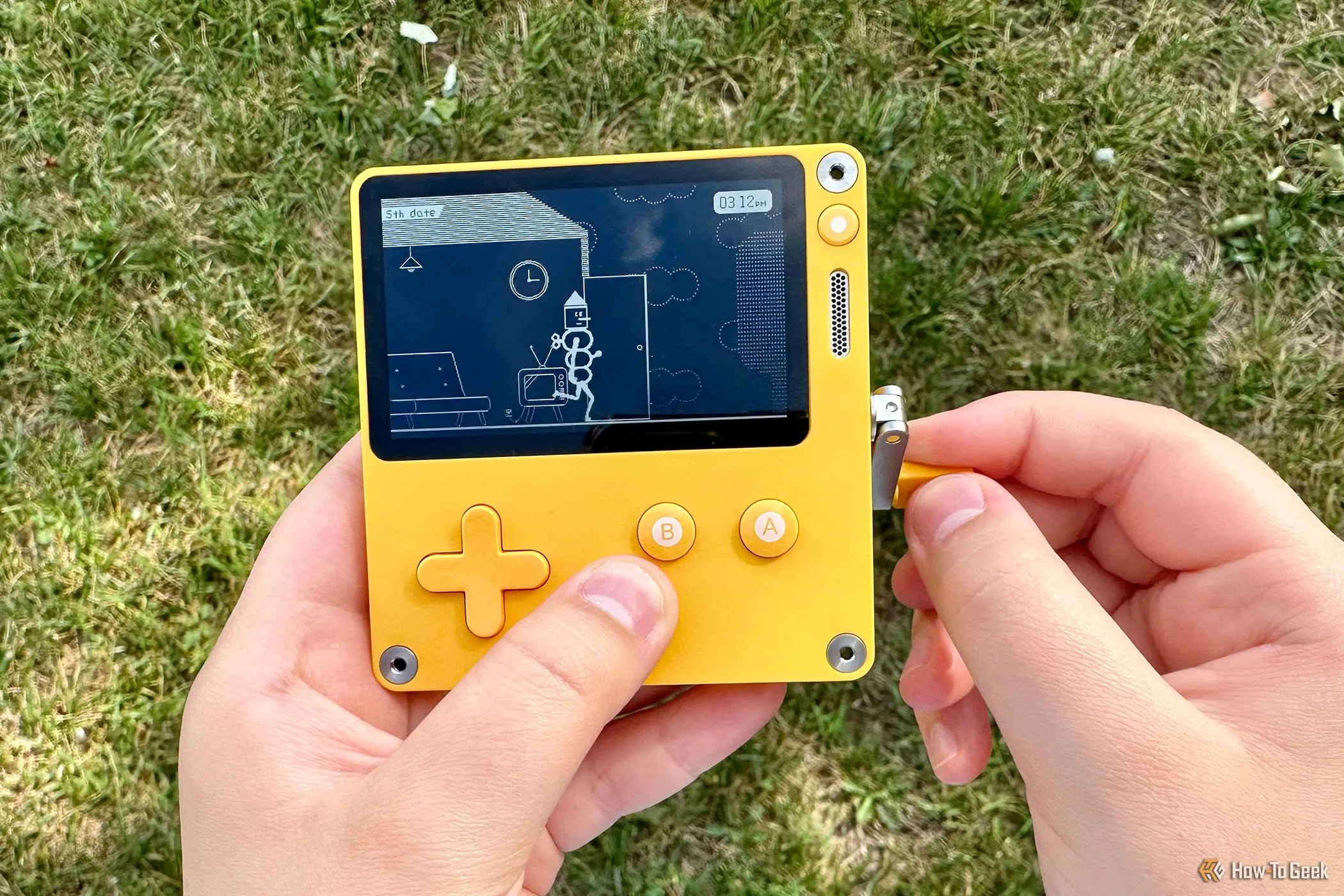 Một người đang trải nghiệm game trên máy Playdate với cần quay độc đáo.
