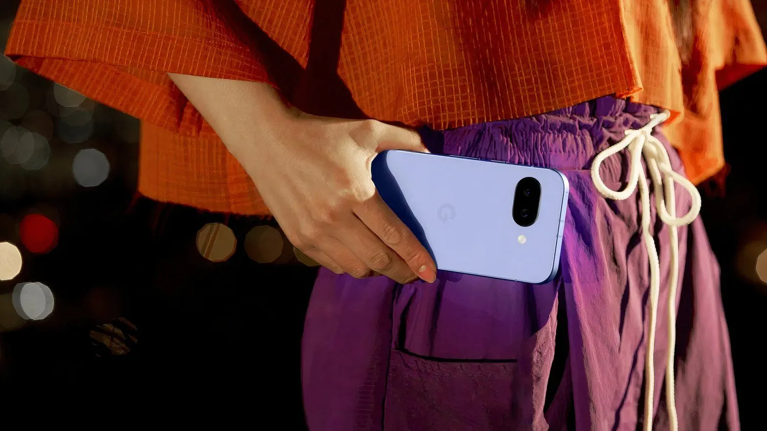 Một người phụ nữ đang cầm và sử dụng điện thoại Google Pixel 9a.