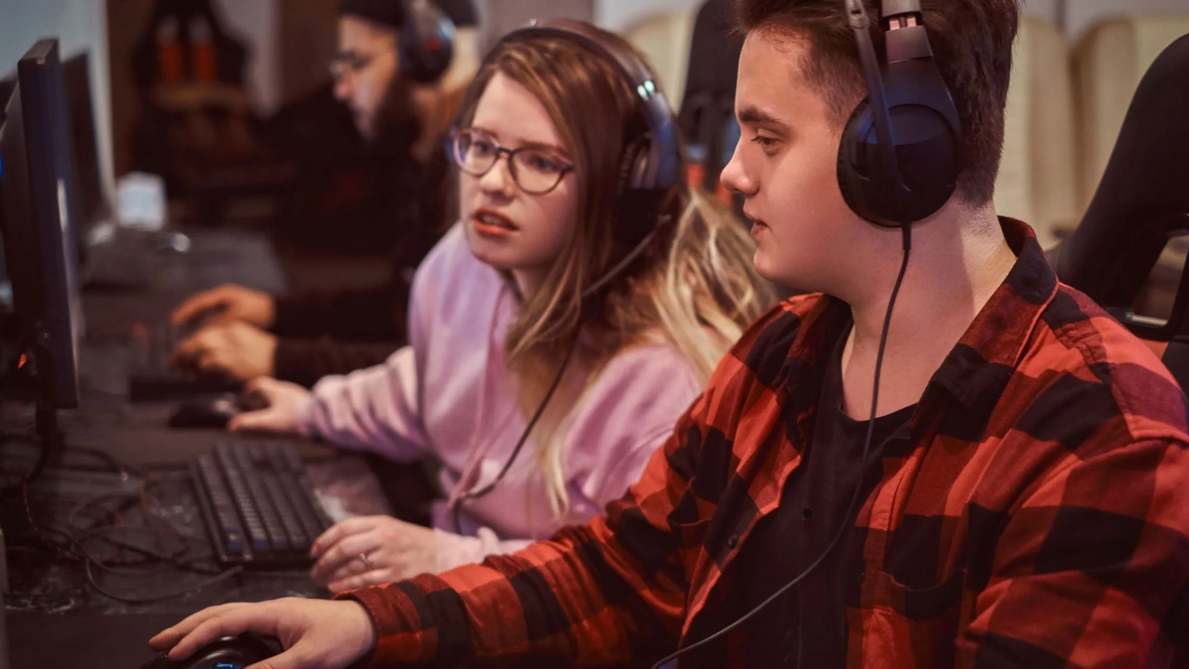 Một nhóm game thủ đang chơi game nhiều người chơi trên máy tính tại câu lạc bộ, minh họa cho sự phát triển của hỗ trợ chống gian lận trên Linux gaming.
