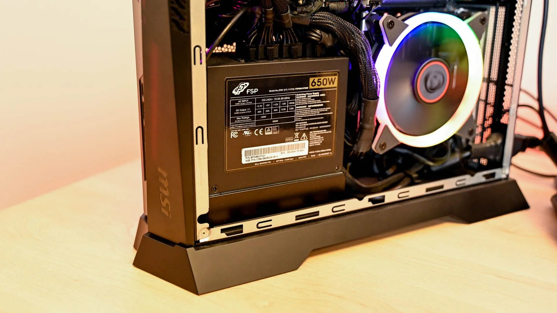 Một thùng máy MSI Trident với bộ nguồn 650W, được nhìn từ phía sau qua lớp kính cường lực