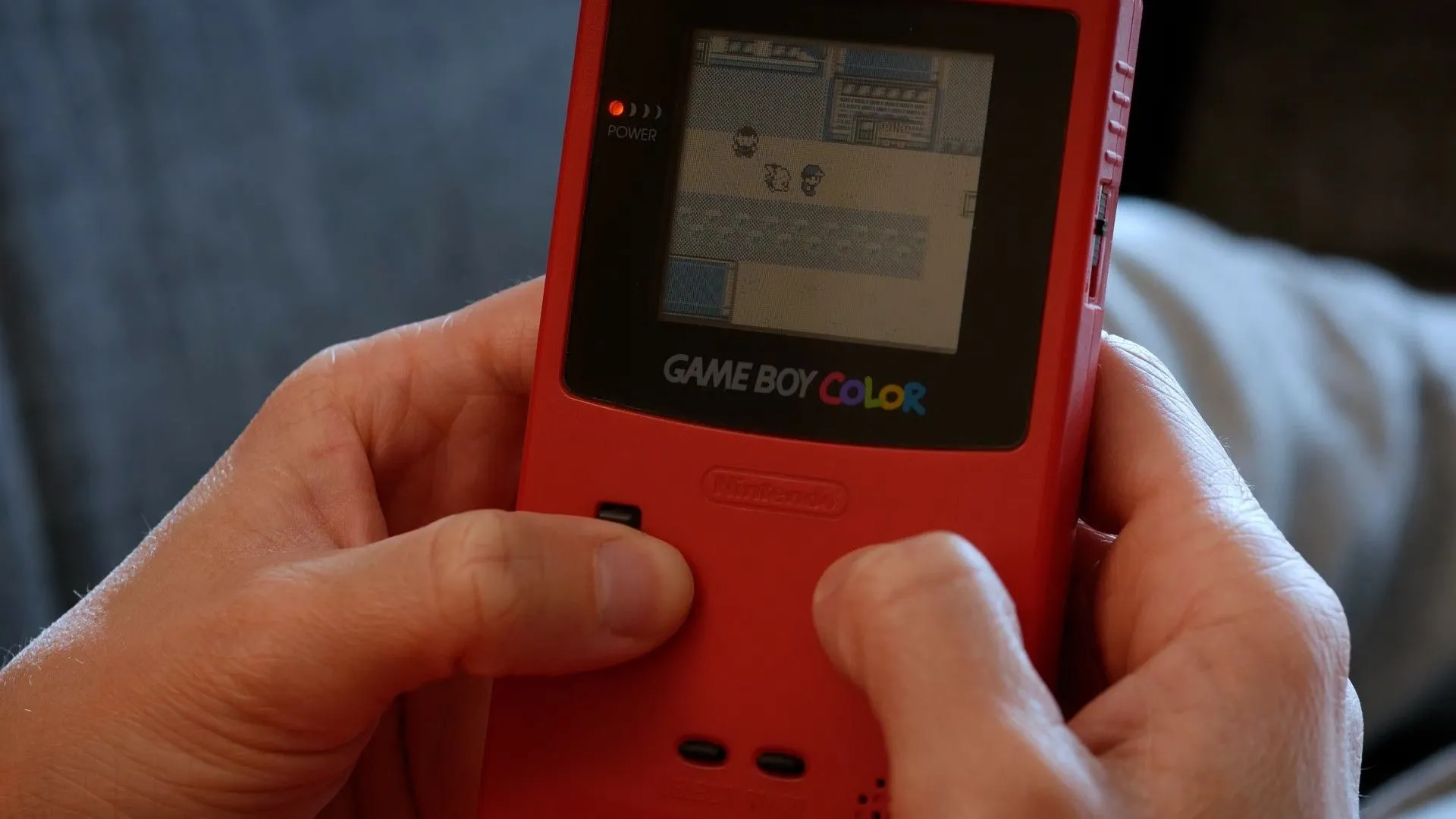 Người chơi tận hưởng trò Pokemon Yellow trên Game Boy Color, một thiết bị chơi game cầm tay kinh điển.