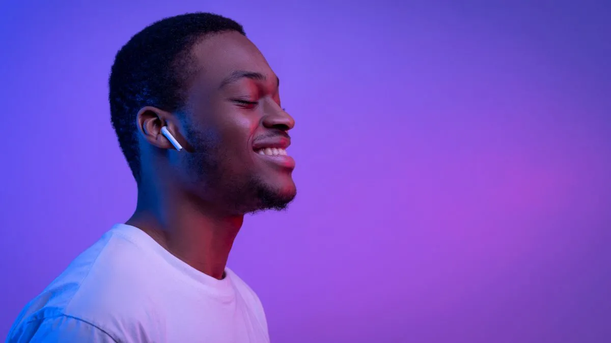 Người đàn ông thư giãn đeo tai nghe Apple AirPods, minh họa cách thiền định bằng âm thanh mà không cần nhìn vào điện thoại
