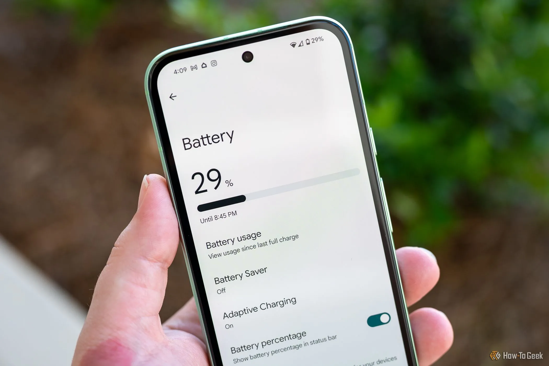 Người dùng cầm điện thoại Google Pixel 8a, hiển thị menu cài đặt pin, minh họa khả năng tối ưu hiệu suất pin trong Android 16 Beta 4