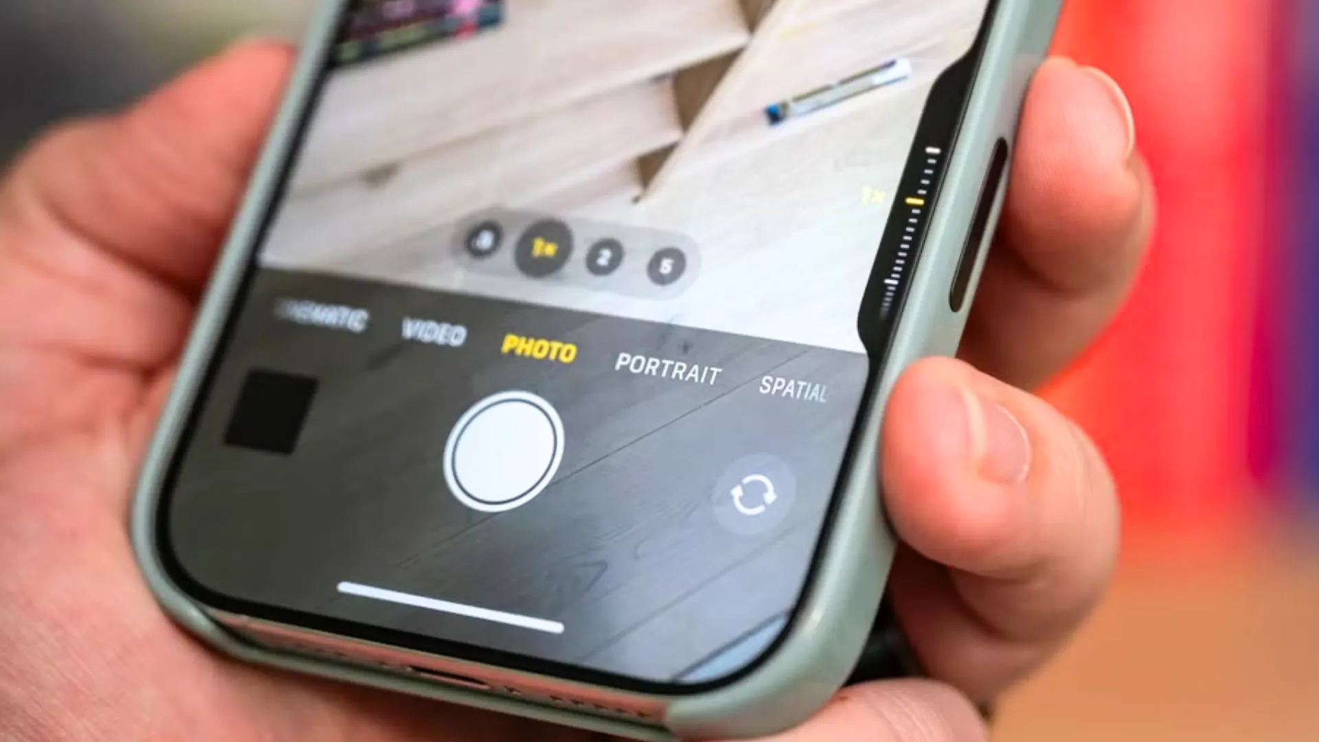 Người dùng cầm iPhone 16, giao diện camera hiển thị nút Camera Control mới tiện lợi