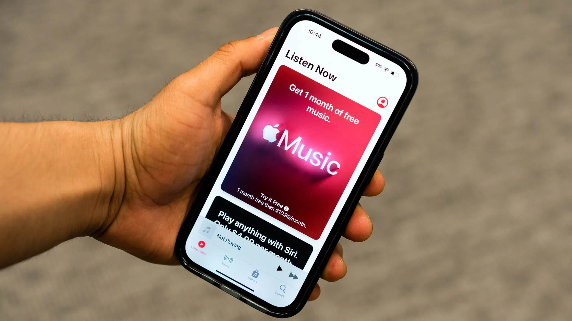 Người dùng cầm iPhone hiển thị ứng dụng Apple Music, trải nghiệm giải trí âm nhạc liền mạch