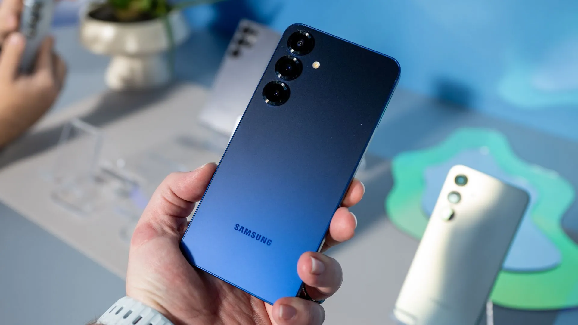 Người dùng cầm Samsung Galaxy S25 màu xanh Navy, thể hiện hệ thống camera sau chất lượng.