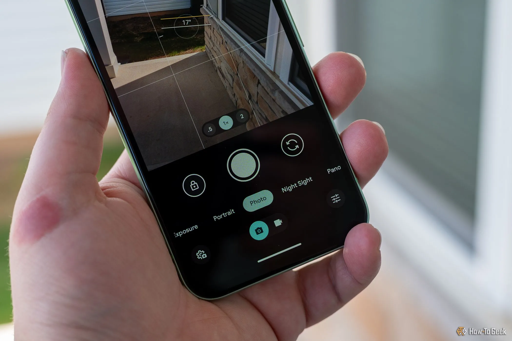 Người dùng đang cầm điện thoại Google Pixel 8a, giao diện ứng dụng camera hiển thị các tính năng chụp ảnh nâng cao và AI.
