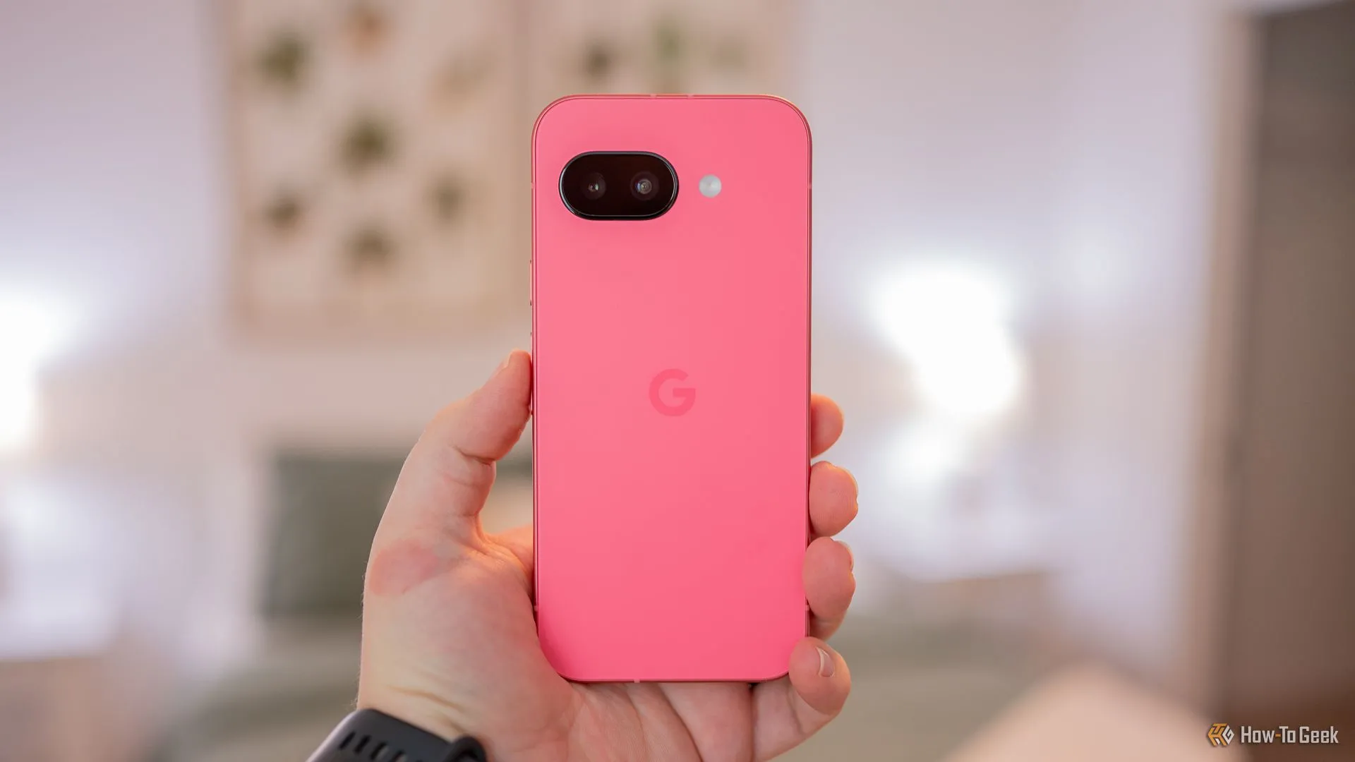 Người dùng đang cầm điện thoại Google Pixel 9a, hiển thị mặt lưng với cụm camera, liên quan đến vấn đề lỗi báo thức