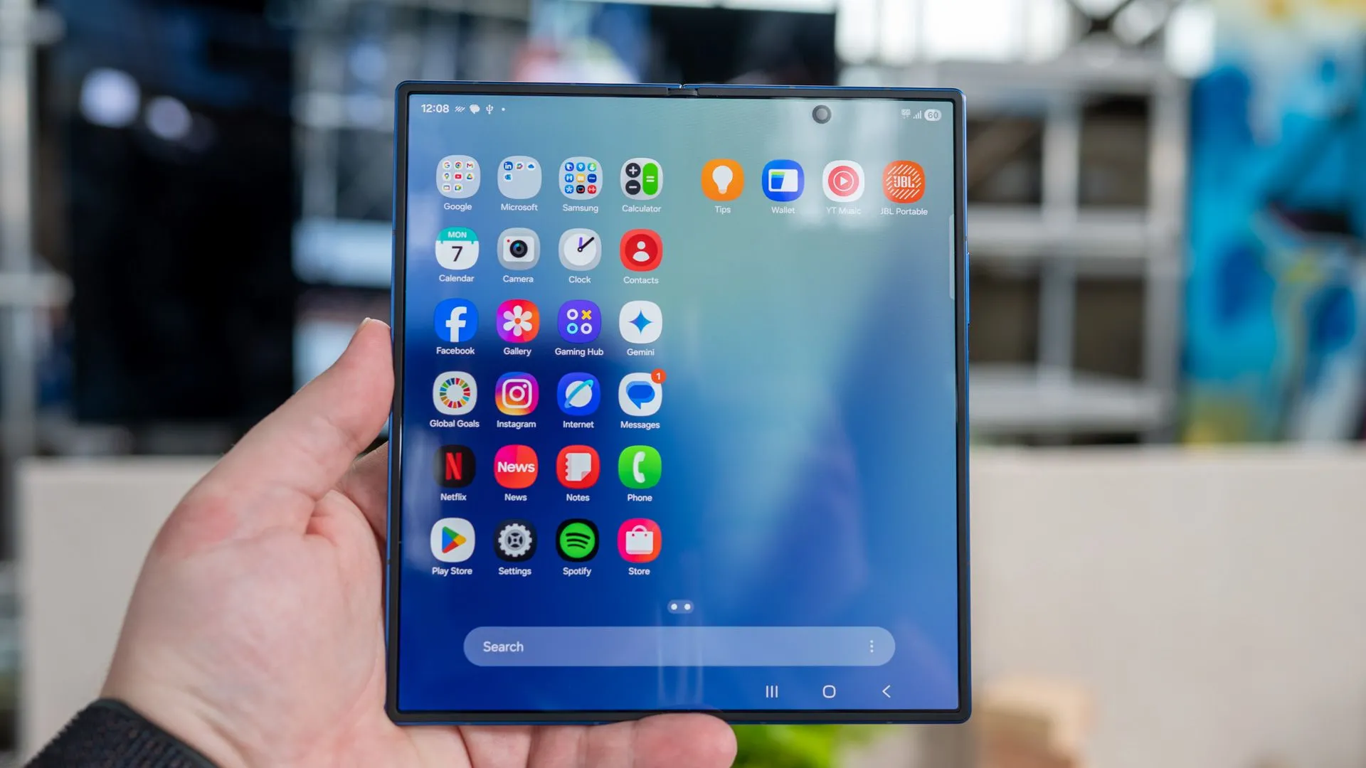 Người dùng đang cầm điện thoại Samsung Galaxy Z Fold 7 gập mở, hiển thị giao diện ứng dụng trên màn hình lớn bên trong
