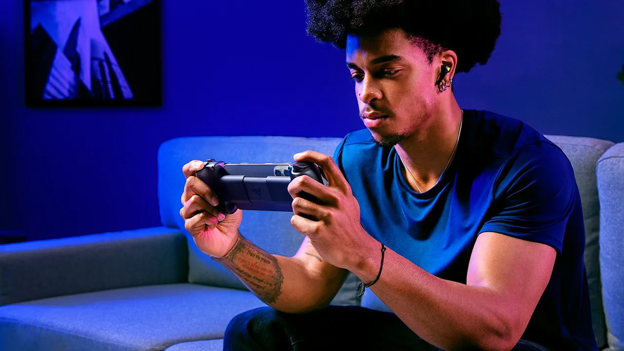Người dùng đang chơi game di động bằng tay cầm Razer Kishi V3 trên ghế sofa.