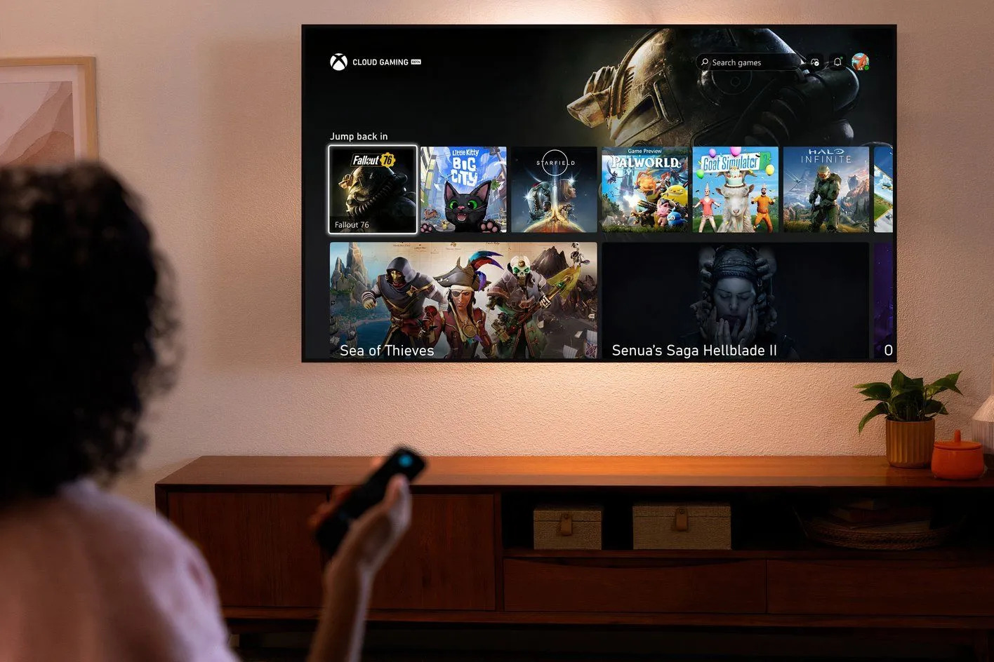 Người phụ nữ sử dụng điều khiển từ xa để duyệt các tựa game Xbox Cloud Gaming trên TV thông minh, thể hiện chiến lược chơi game Xbox không cần console.
