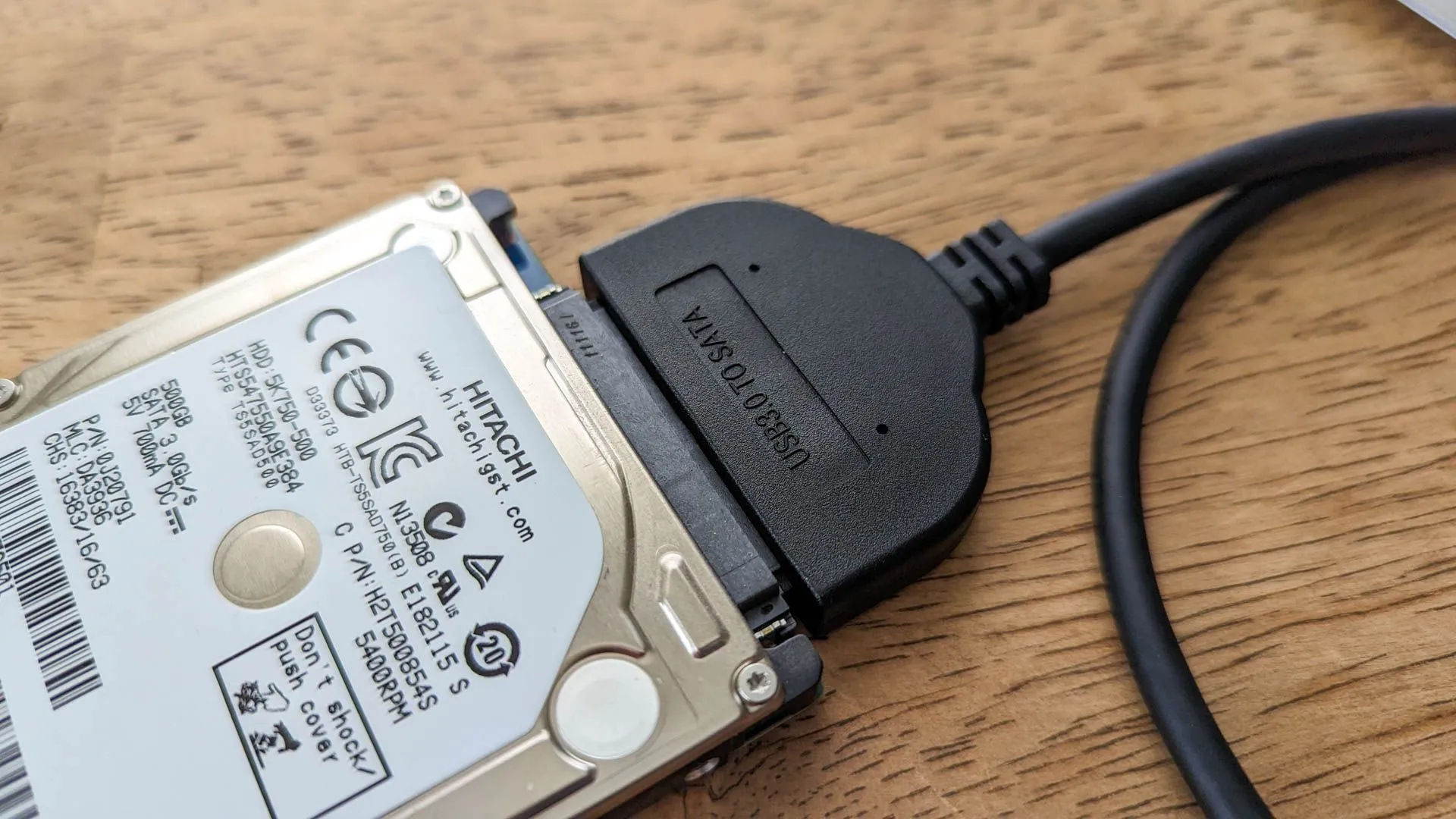 Ổ cứng laptop kết nối qua adapter USB sang SATA, biểu thị tính tiện lợi và khả năng tái sử dụng.