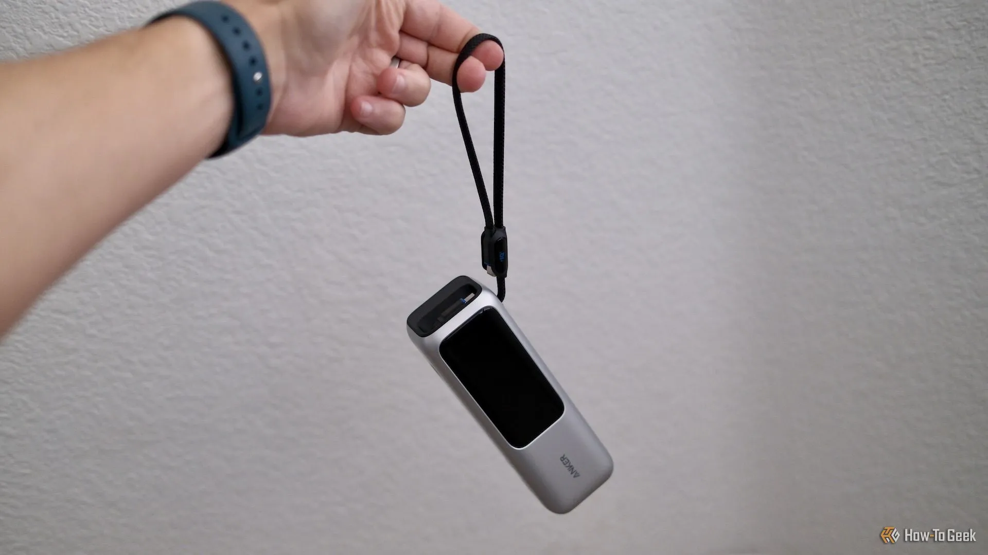 Sạc dự phòng Anker Power Bank 25K đang được giữ bằng dây đeo tay tích hợp