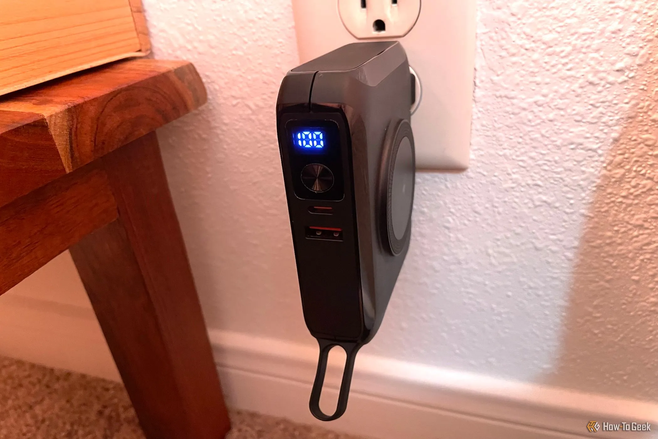Sạc dự phòng Raycon MLPB với chấu cắm AC tích hợp đang cắm trực tiếp vào ổ điện trên tường