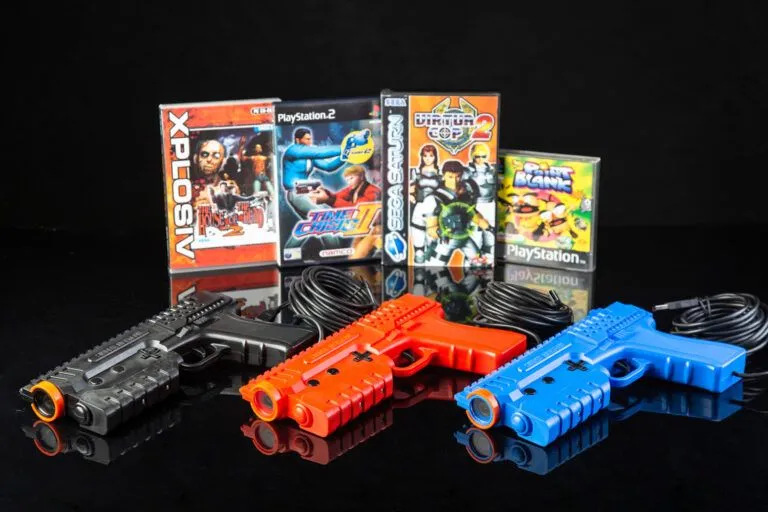 Súng Sinden Lightgun với ba biến thể màu sắc, cùng với hình ảnh bốn game bắn súng light gun cổ điển: The House of the Dead, Time Crisis II, Virtua Cop 2 và Point Blank.