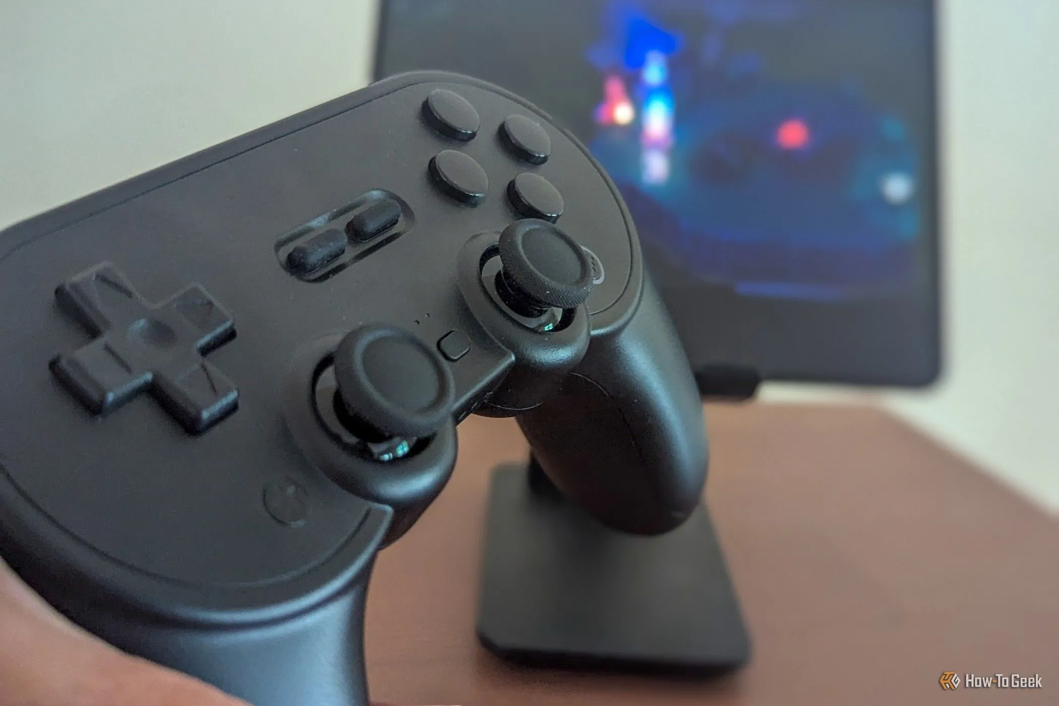 Tay cầm 8BitDo Pro 2 với trò chơi di động ở hậu cảnh