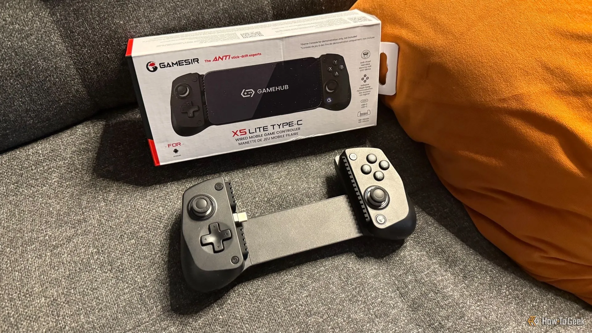 Tay cầm chơi game di động GameSir X5 Lite và hộp đựng đặt trên ghế sofa, gợi ý tính di động và sự tiện lợi.