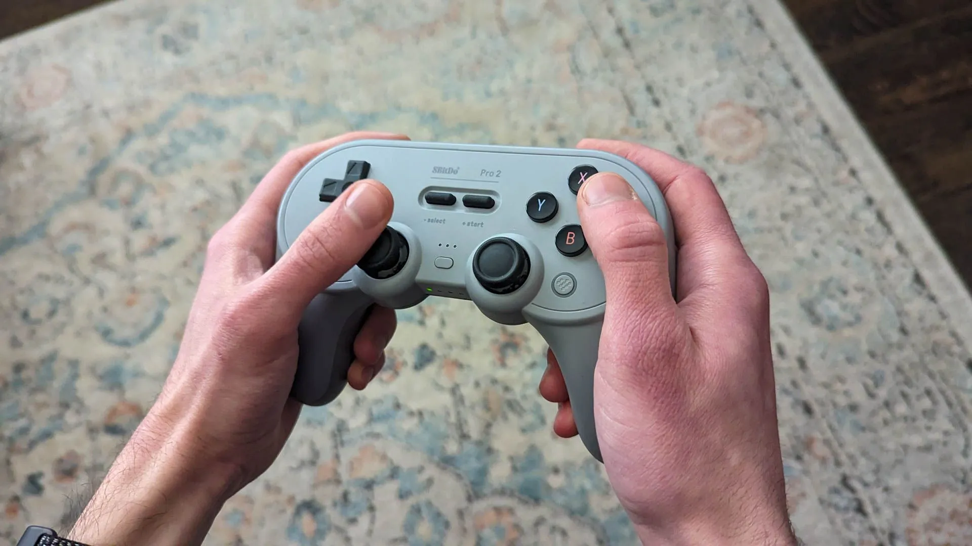 Tay cầm chơi game không dây 8Bitdo Pro 2 trong lòng bàn tay, thiết kế cổ điển.