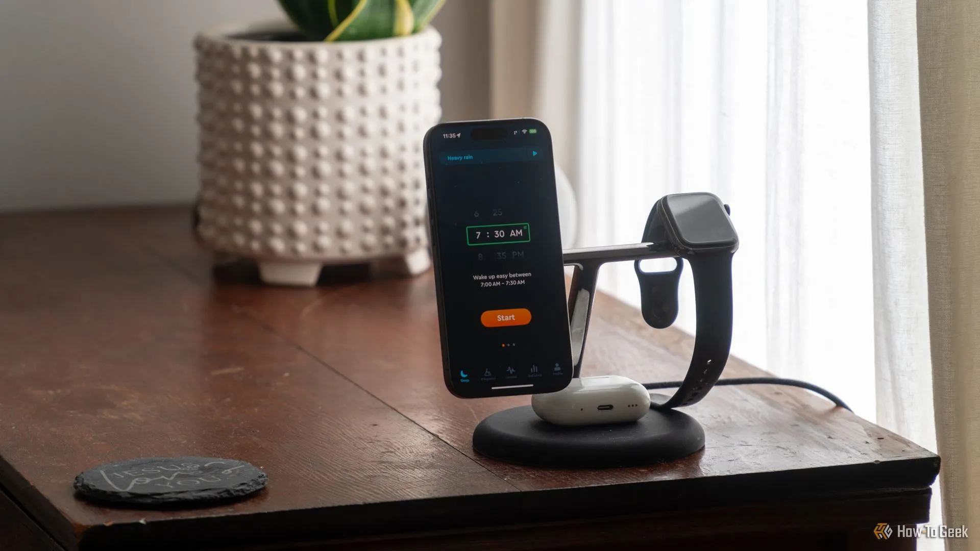 Ứng dụng Sleep Cycle trên iPhone 15 Pro đặt cạnh Apple Watch và AirPods Pro trên tủ đầu giường, minh họa cách thiết lập theo dõi giấc ngủ.