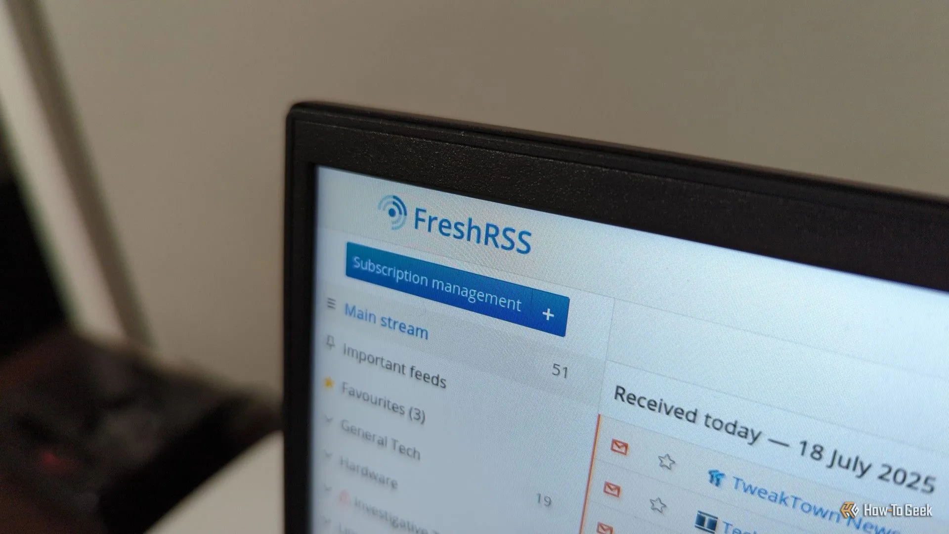 Logo FreshRSS hiển thị trên màn hình laptop.