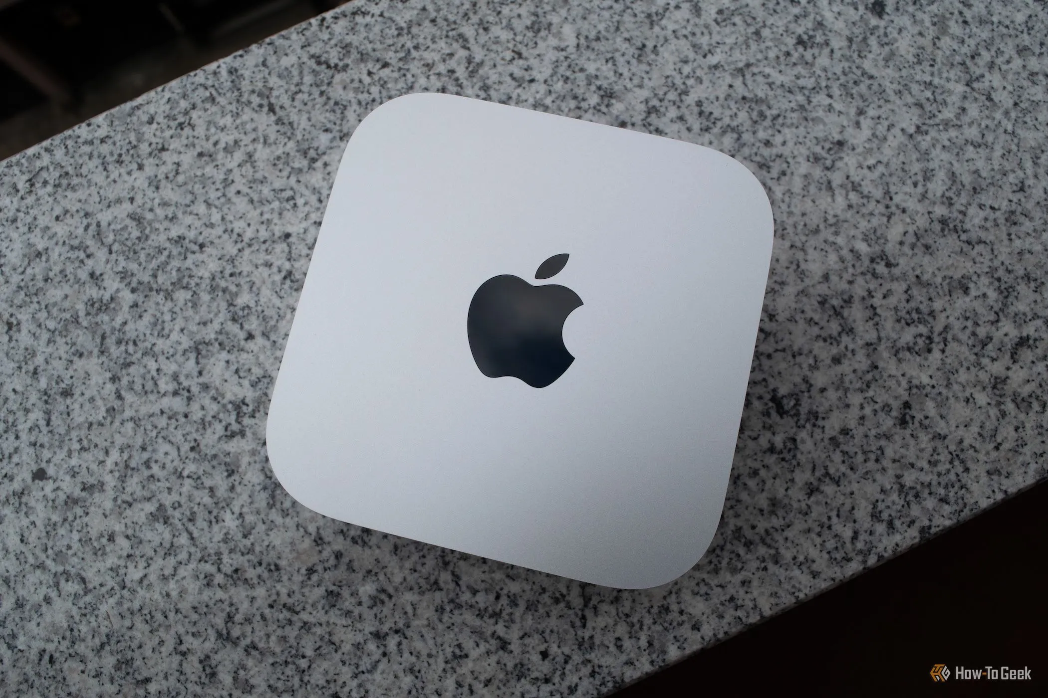 Mac Mini M4 đặt trên mặt bàn đá granite, nhấn mạnh thiết kế nhỏ gọn và cao cấp